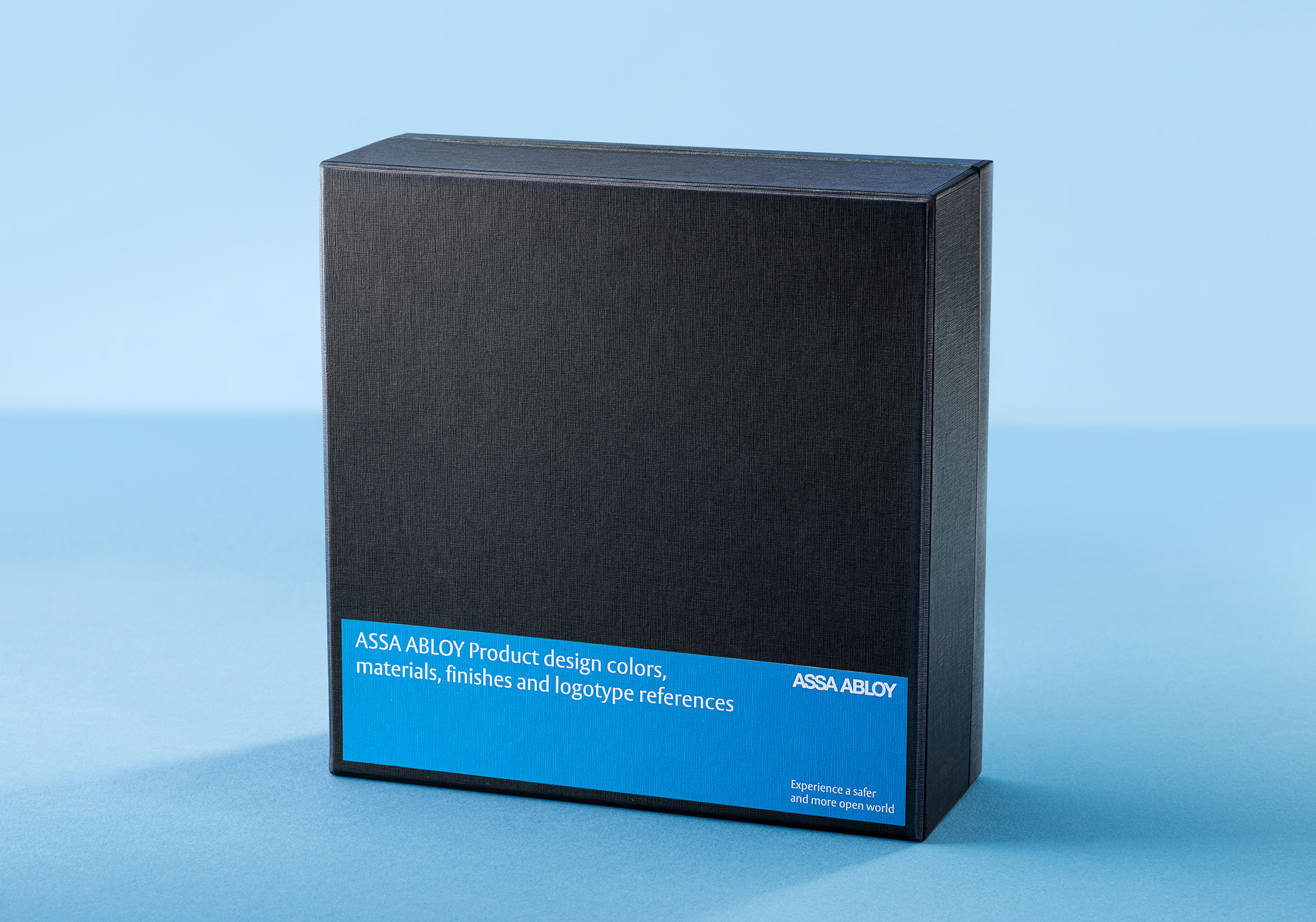 Scatola nera ASSA ABLOY per referenze di design, colori, materiali e finiture, su fondo azzurro chiaro
