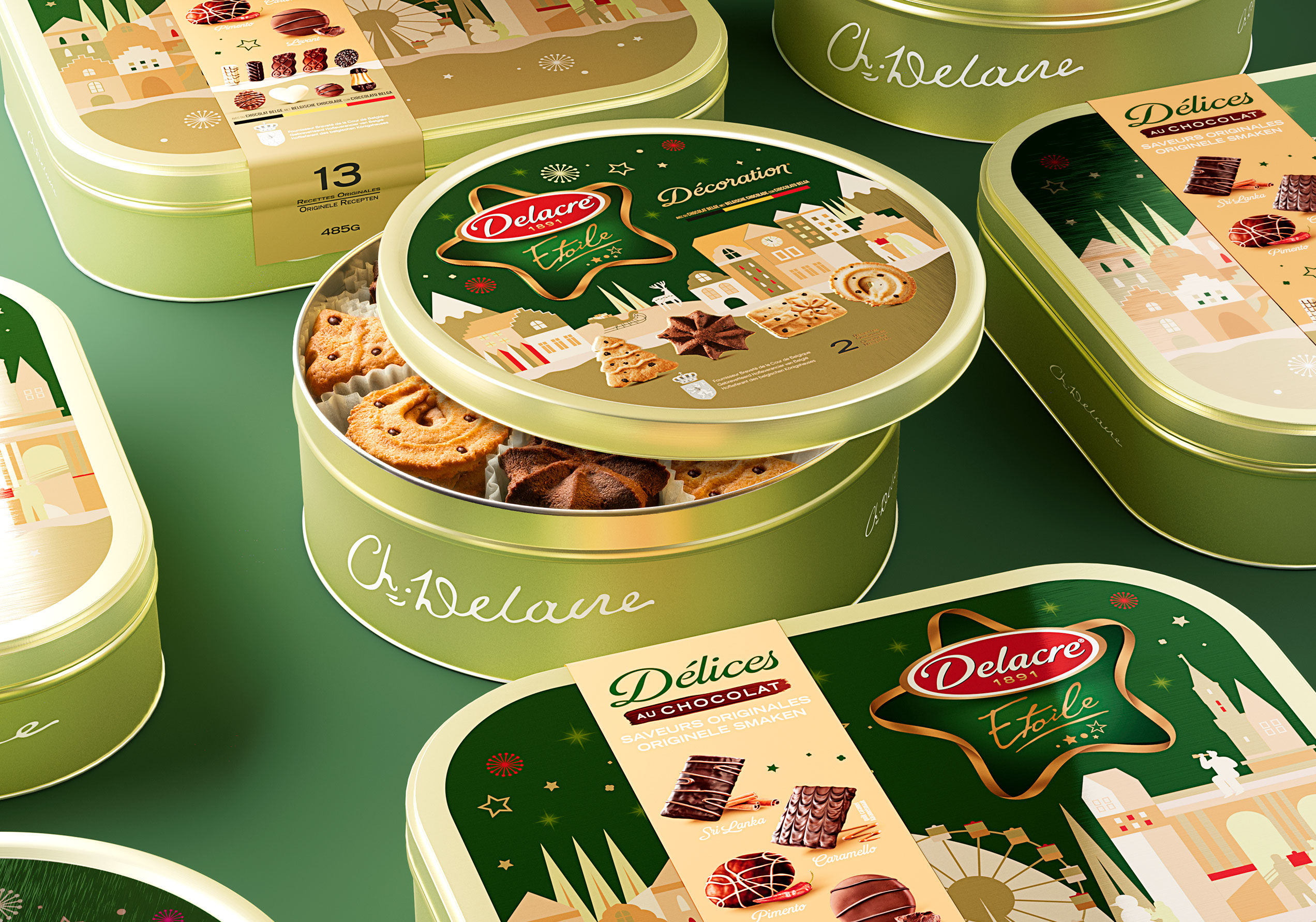 Scatole di latta Delacre Étoile aperte, con biscotti decorati visibili all’interno, disposte su fondo verde con grafica natalizia