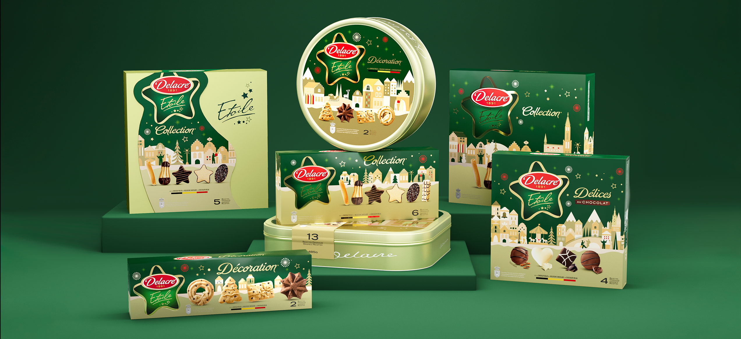 Collezione di confezioni natalizie Delacre Étoile con biscotti assortiti in scatole regalo decorate con paesaggi invernali illustrati su sfondo verde