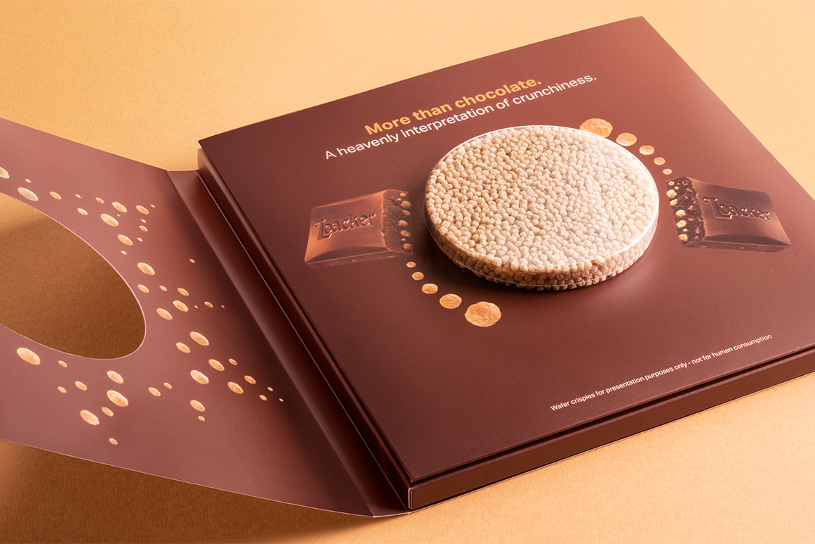 Confezione aperta Loacker Choco-Crisp con visual ‘More than chocolate’ e wafer tondo in evidenza