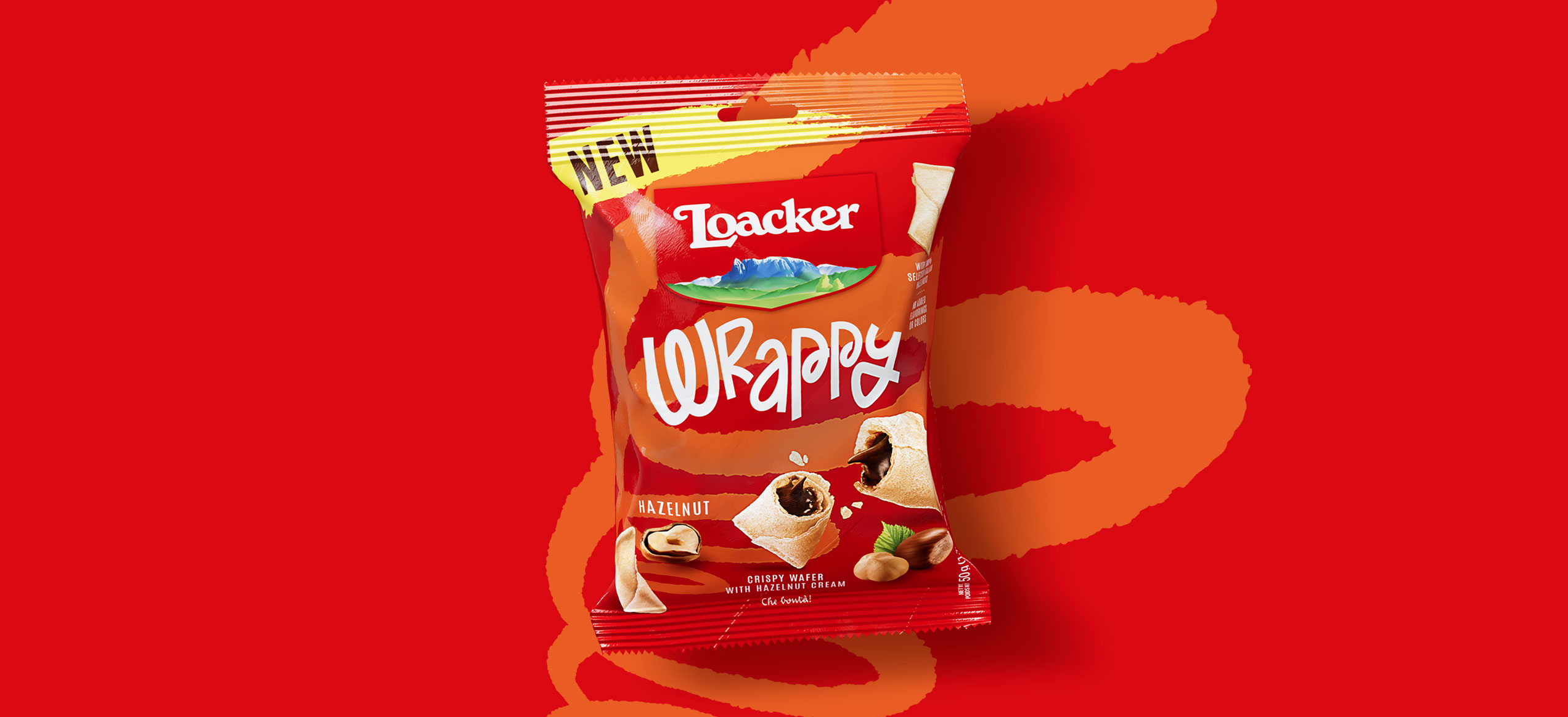 Confezione Loacker Wrappy hazelnut su sfondo rosso con pattern decorativo arancione