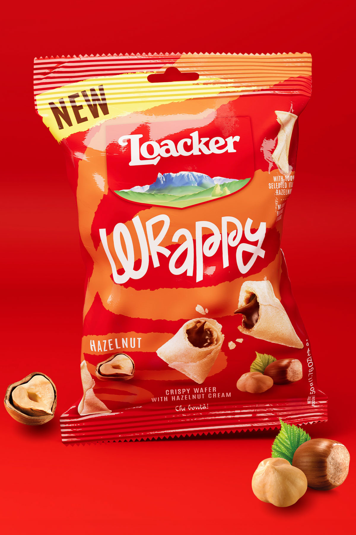 Pack singolo di Loacker Wrappy gusto hazelnut in primo piano con ingredienti visibili sul fondo