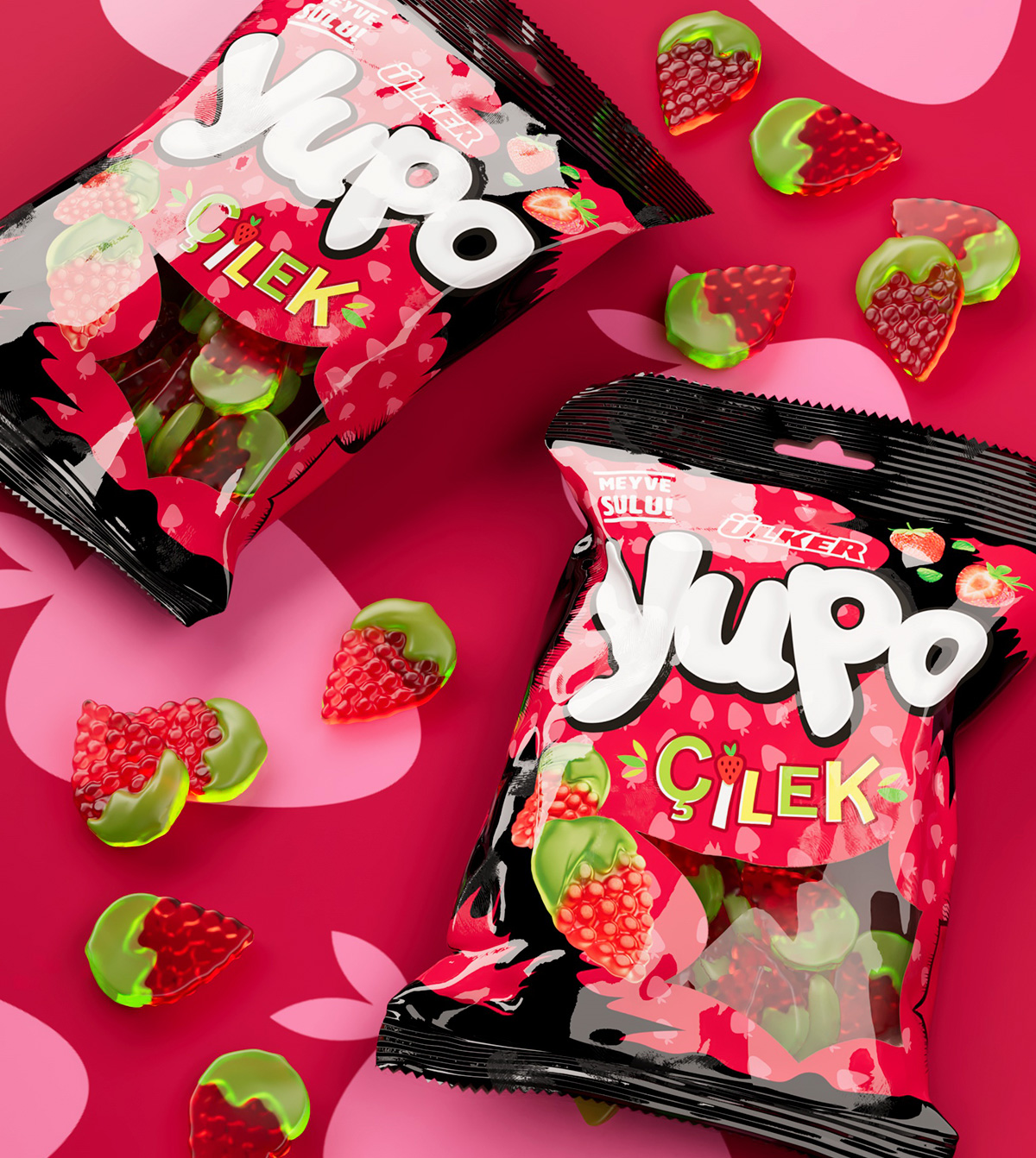 Confezioni di Yupo gusto fragola adagiate su uno sfondo rosa con grafiche a forma di frutta, accompagnate da caramelle a forma di fragola con base verde